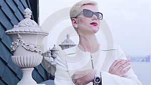Beautiful blond business women wearing sunglasses white jacket waiting meeting speak phone city streets
