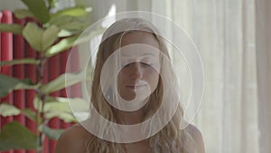 Beautiful blond caucasian young woman is making meditation with sage smudge sticks. Video footage still shot portrait.