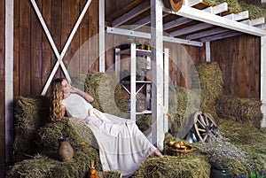 Beautiful blond fashionable woman on hay barn