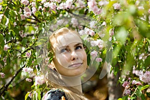 Beautiful blond girl in blossom garden