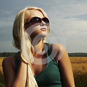 Beautiful blond girl on the field.beauty woman.sunglasses