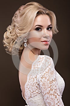 Beautiful blond girl in image of the bride with purple flowers on her head. Beauty face