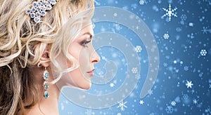 Beautiful blond girl with luxury golden necklace over blue winter background. Christmas concept.