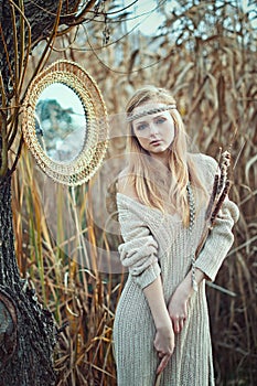 Beautiful blond girl with a mirror in the reeds