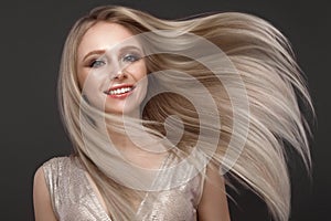 Beautiful blond girl in move with a perfectly smooth hair, and classic make-up. Beauty face.