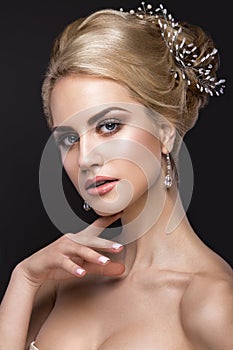 Beautiful blond girl with perfect skin, evening make-up, wedding hairstyle and accessories. Beauty face.