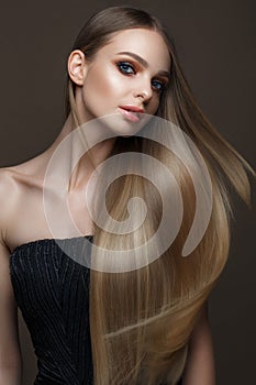 Beautiful blond girl with a perfectly smooth hair, classic make-up. Beauty face