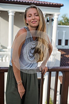 The beautiful blond girl posing on the street in fashionable clothes.