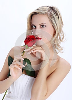 Beautiful blond girl with red rose flower on a white background