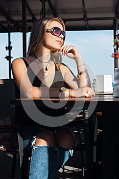 Beautiful blond girl sits at a table in a cafe