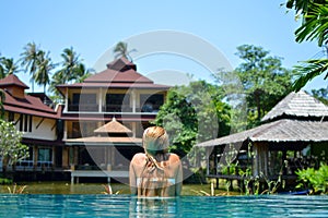 Beautiful blond girl is swimming in the pool