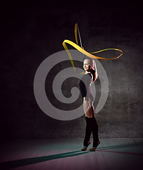Beautiful Blond Hair girl gymnast training with the gymnastics tape. Flexible gymnastics girl doing exercises