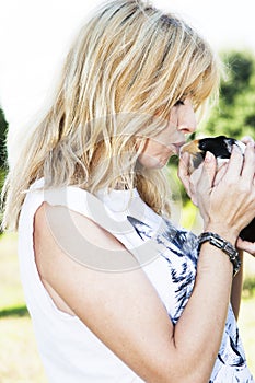 Beautiful blond hair woman kissing cute pet Peruvian guinea pig