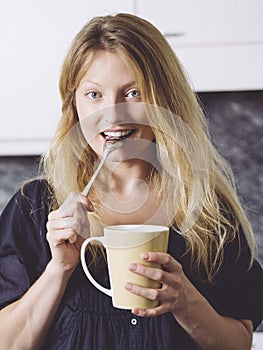 Beautiful blond having coffee in her kitchen