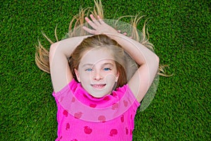 Beautiful blond kid children girl smiling lying on grass