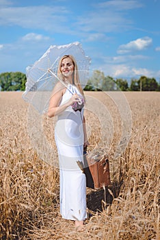 Beautiful blond lady with umbrella and suitcase