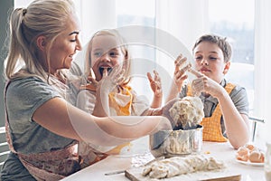 Mom cooking with kids on the kitchen photo