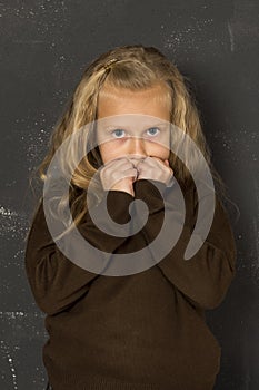 Beautiful blond schoolgirl sad moody and tired in front of school class blackboard