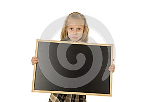 Beautiful blond schoolgirl sad moody and tired holding and showing small blank blackboard