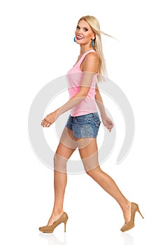 Beautiful Blond Smiling Woman Is Walking. Side View.