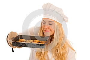 Beautiful blond woman in chef dress bakes cookies isolated over