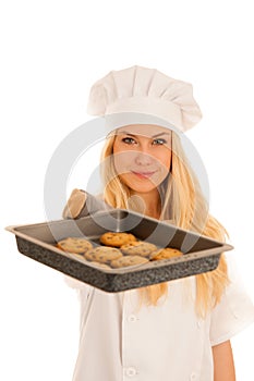 Beautiful blond woman in chef dress bakes cookies isolated over