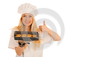 Beautiful blond woman in chef dress bakes cookies isolated over