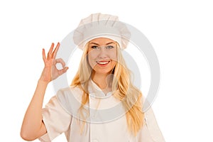 Beautiful blond woman in chef dress bakes cookies over