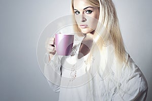 Beautiful blond woman drinking Coffee. Cup of tea