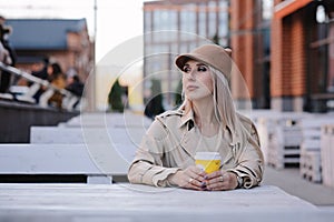 Beautiful blond woman drinking coffee in outdoor cafe