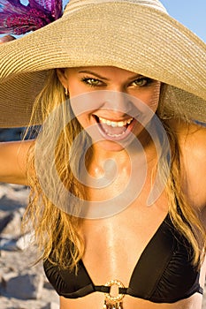 Beautiful blond woman in a hat on a beach