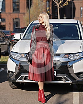 Beautiful blond woman at her white car, jeep, sport utility