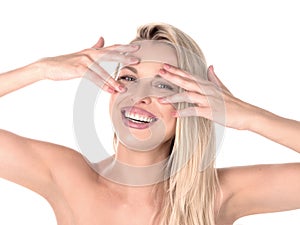 Beautiful blond woman with long hair touching her face on whie background. Perfect smile. Stomatology concept