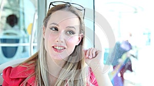 Beautiful blond woman riding tram, looking to the camera, commenting