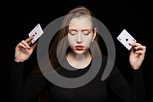 Beautiful blond woman showing a poker card on black background