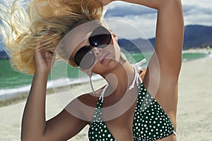 Beautiful blond woman in sunglasses on the beach. beauty girl in bikini. summer holidays