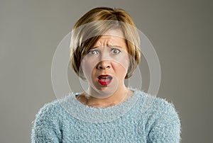 Beautiful blond woman in surprise and shock face expression expressing anxiety and fear