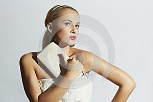 Beautiful blond woman in white dress.Fashion Stylish girl with white clutch.Red lips.Bride