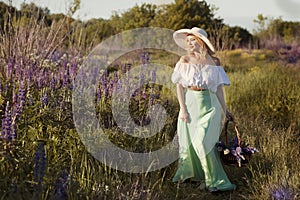 beautiful blond woman in white hat on lupin field summer background close up portrait