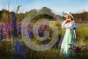 beautiful blond woman in white hat on lupin field summer background close up portrait