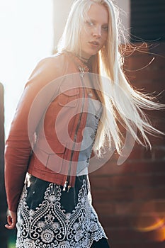 Beautiful blond woman with wind in her hair backlit by sunshine