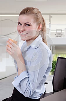 Beautiful Blond Young Businesswoman in Office with Coffee