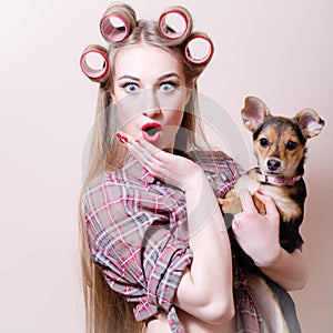 Beautiful blond young pinup woman blue eyes girl having fun playing with cute small dog looking at camera