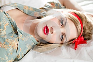 Beautiful blond young woman pinup girl in bed