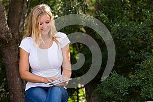 Beautiful blond young women having internet coverage outdoor