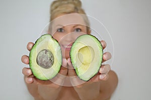 Beautiful blonde avocado woman in front of camera, close-up