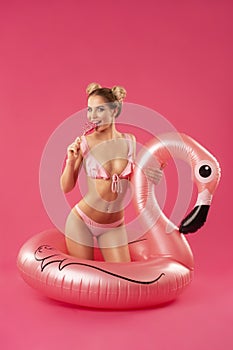 Beautiful blonde in a bathing suit with an inflatable flamingo