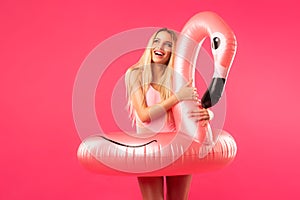 Beautiful blonde in a bathing suit with an inflatable flamingo