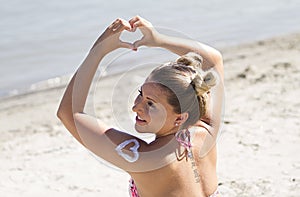 Beautiful blonde.On the beach.She has a modern hairstyle.She has a tattoo on his back.