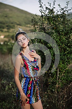 Beautiful blonde with beautiful eyes in blue overalls in nature, sunset sun